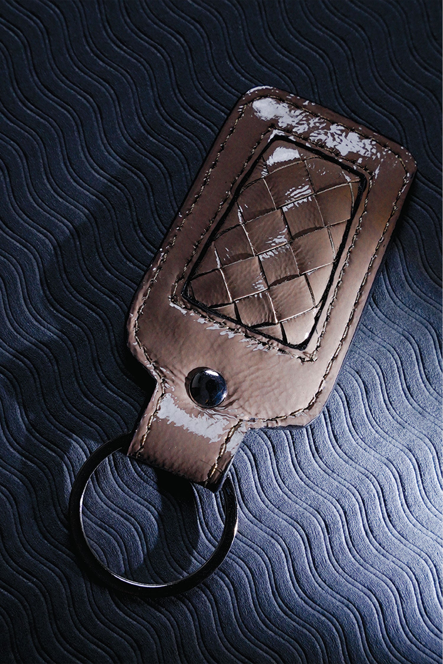 Leather key chain in grey brown colour with weaving and metal ring by JULKE