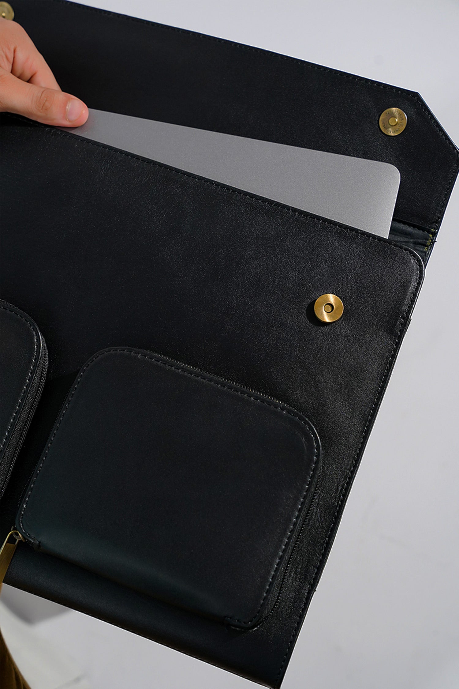 Leather laptop sleeve in black colour with front pockets by JULKE