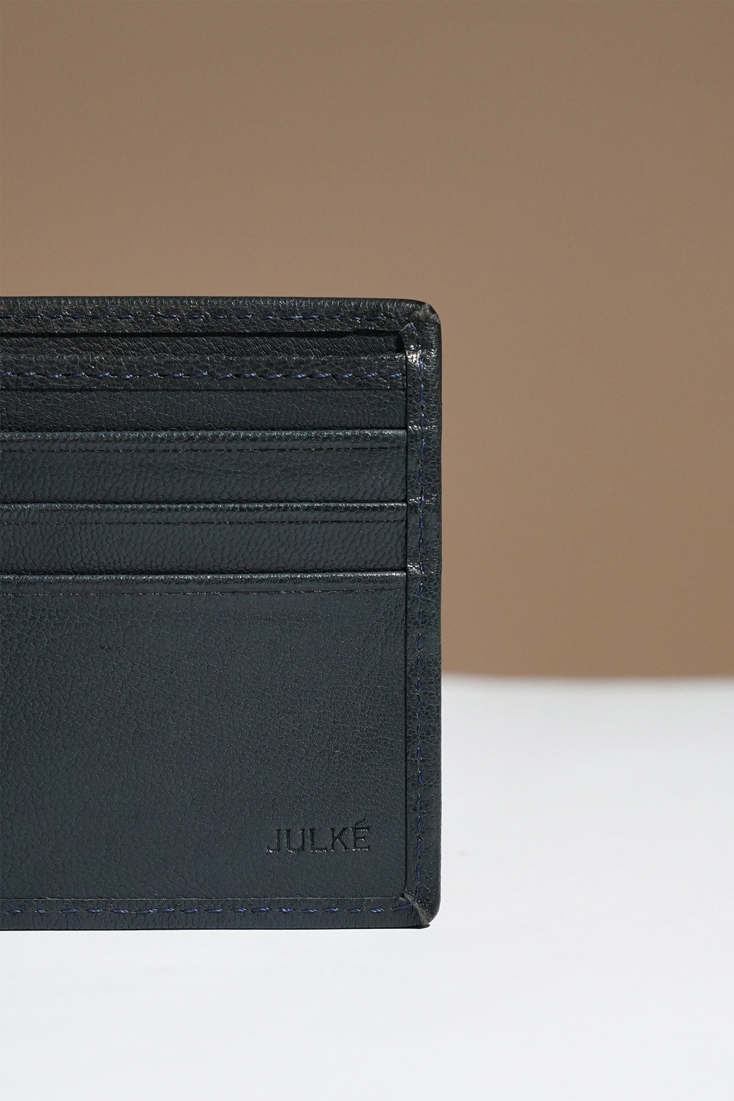 Mens leather bifold wallet in dark blue colour with white contrast stich and metallic hardware by JULKE