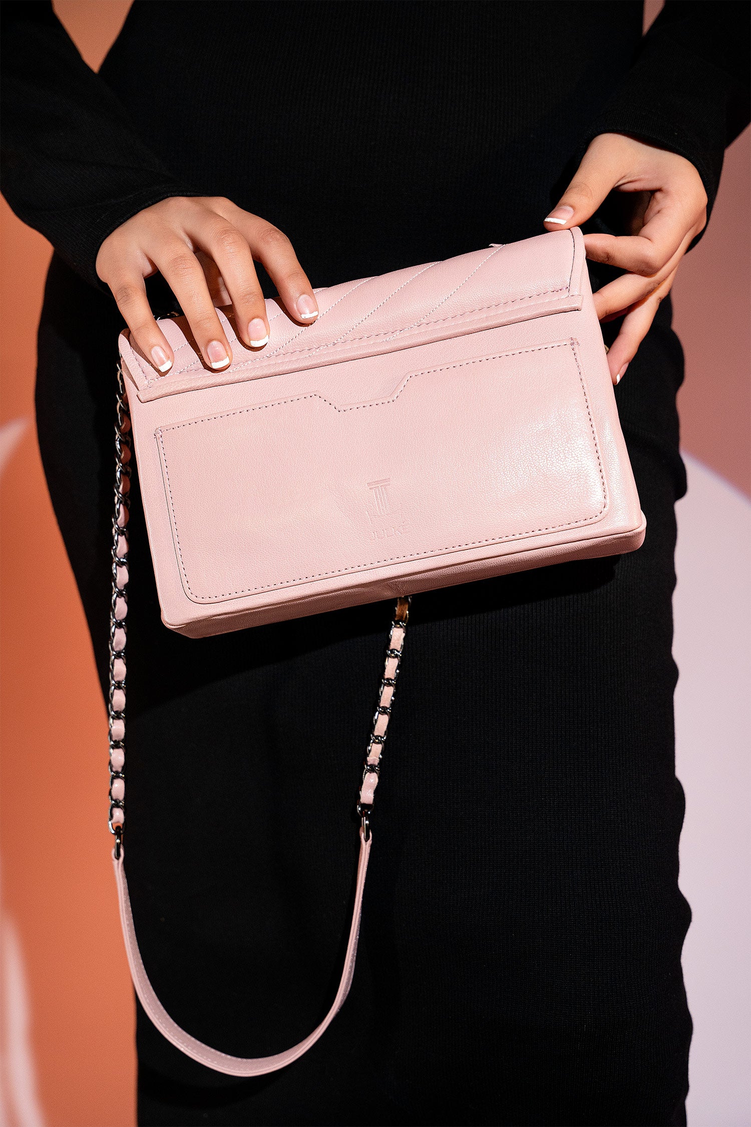 Women's leather shoulder bag in light pink colour with quilting and leatherette flower brooch by JULKE.