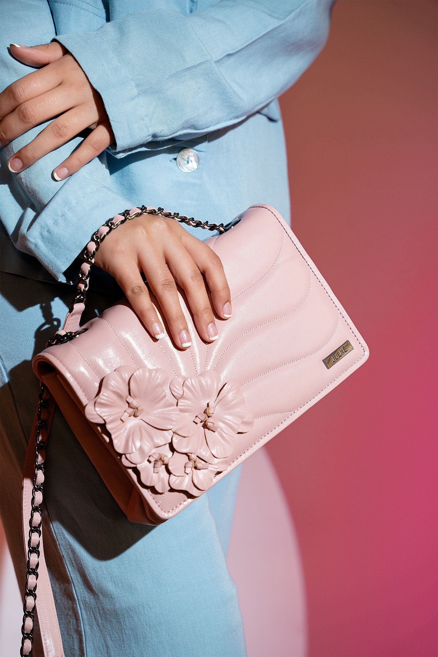 Women's leather shoulder bag in light pink colour with quilting and leatherette flower brooch by JULKE.