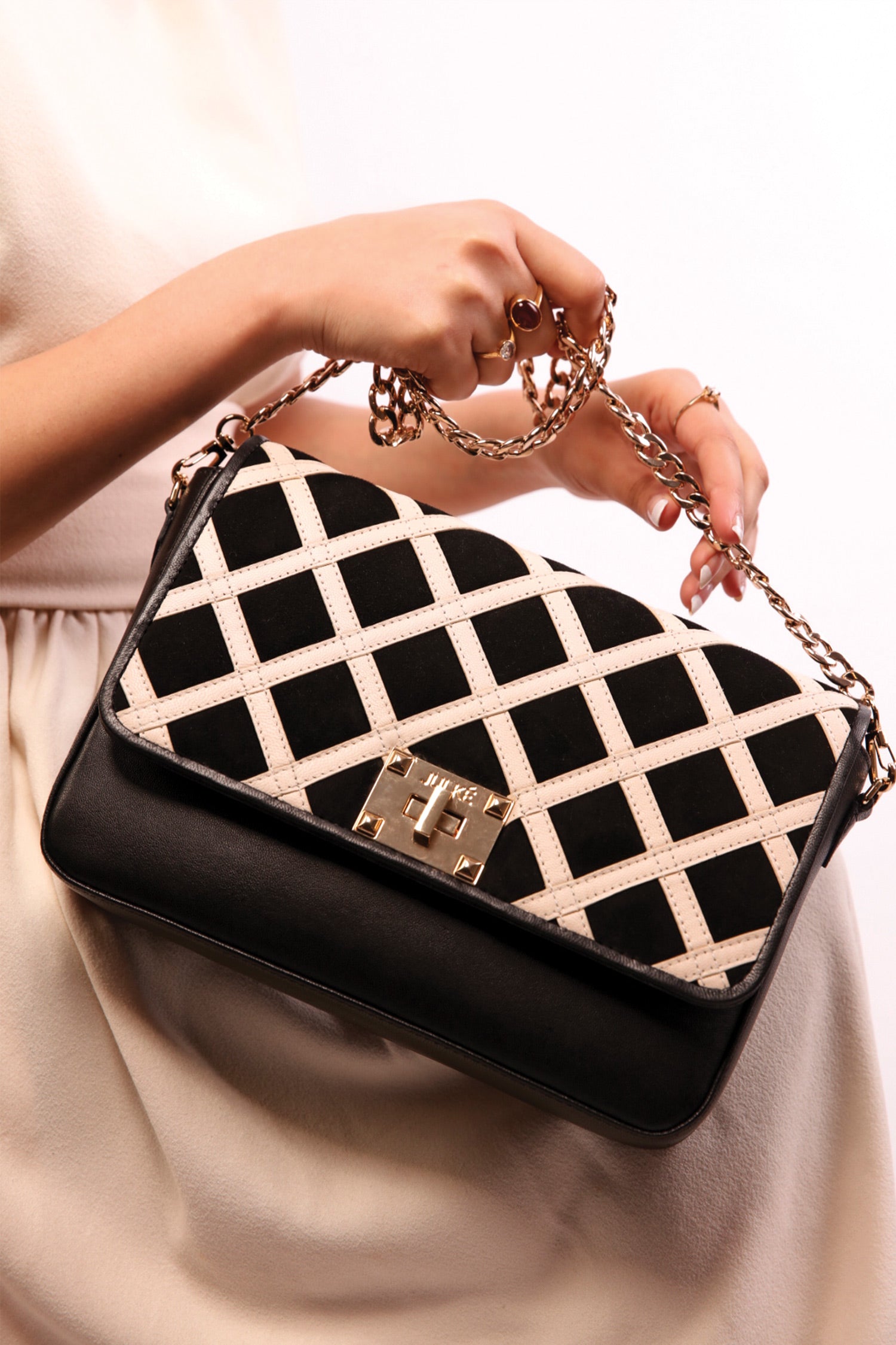 Womens leather shoulder bag in beige and black colour with quilted straps and gold chain by JULKE