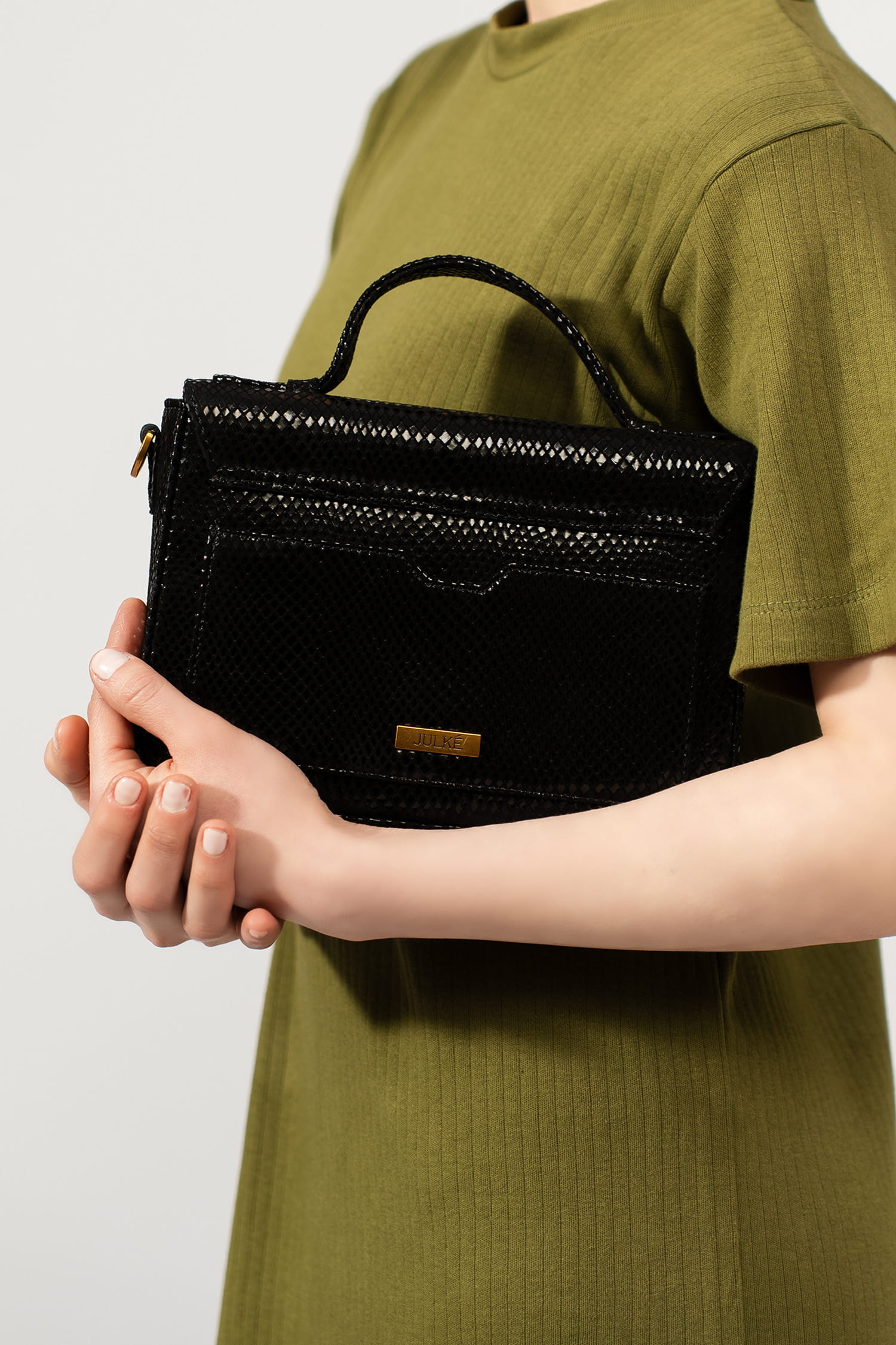 Womens leather top handle shoulder bag in glossy black reptile texture with unique golden metallic lock and metallic chain strap by JULKE.