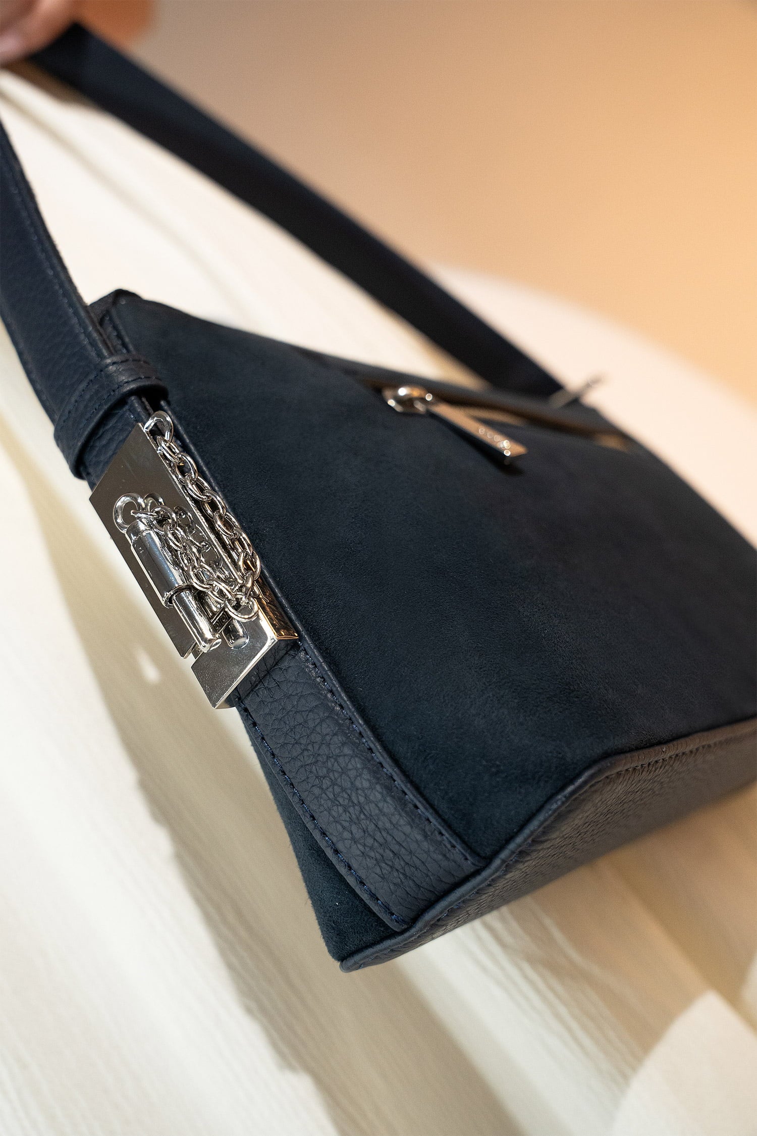 Women's suede leather mini shoulder bag in navy blue colour with contrast shoulder strap and metallic side lock by JULKE.