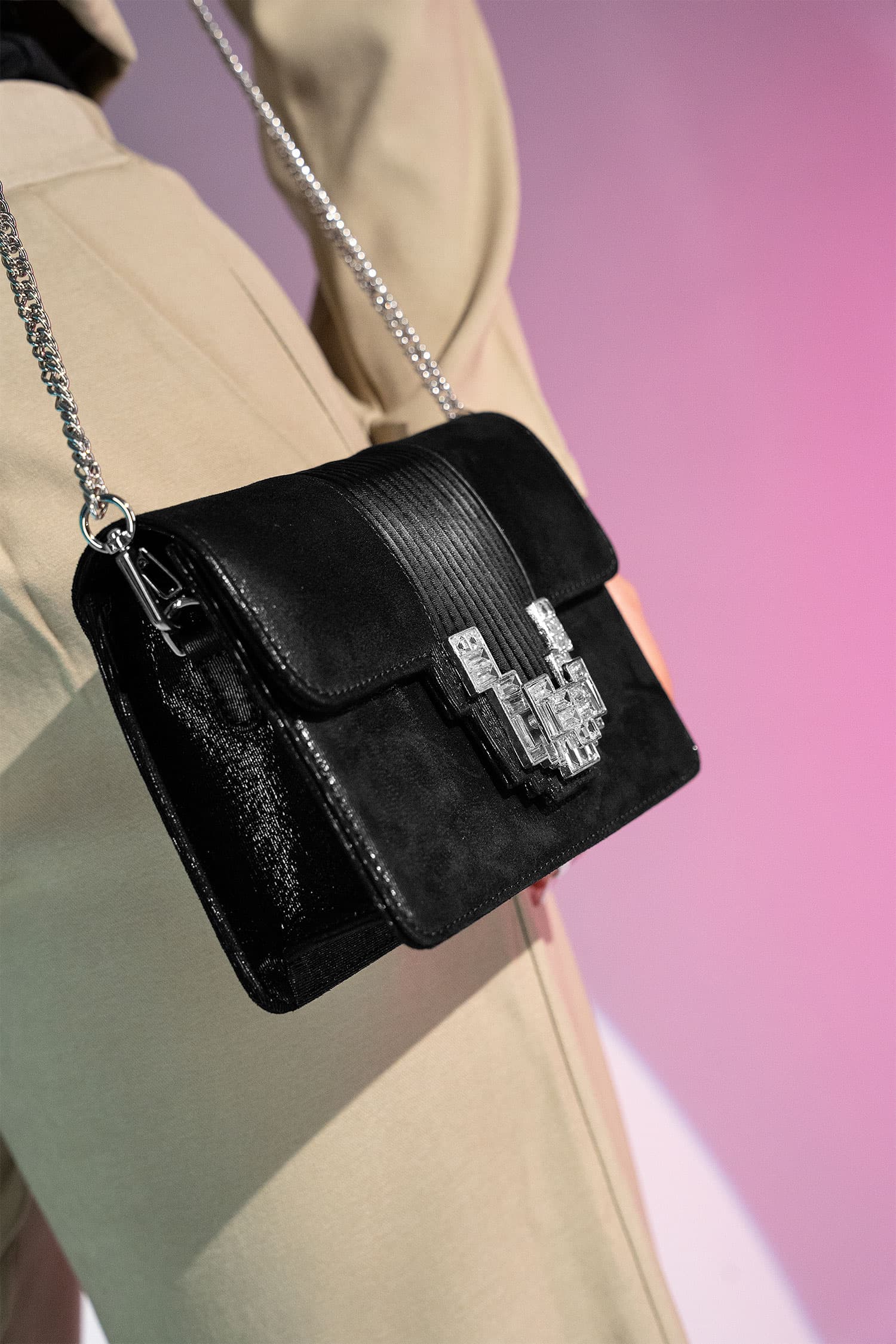 Women's suede leather clutch bag in shiny black colour with satin pleated flap and geometric transparent rhinestone brooch by JULKE.