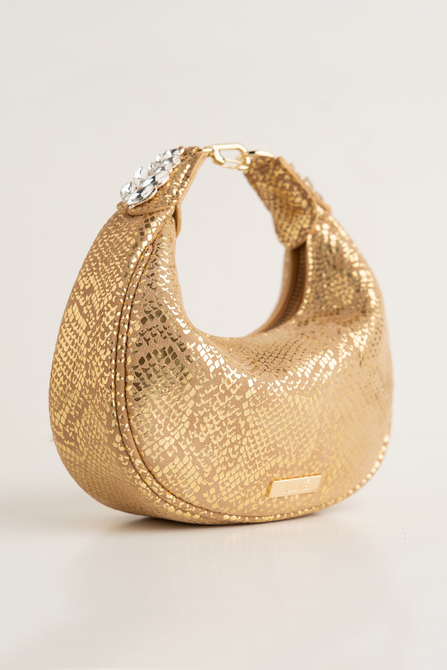 Women's leather mini halfmoon bag in gold colour with 3d reptile texture and unique clip-on handle by JULKE