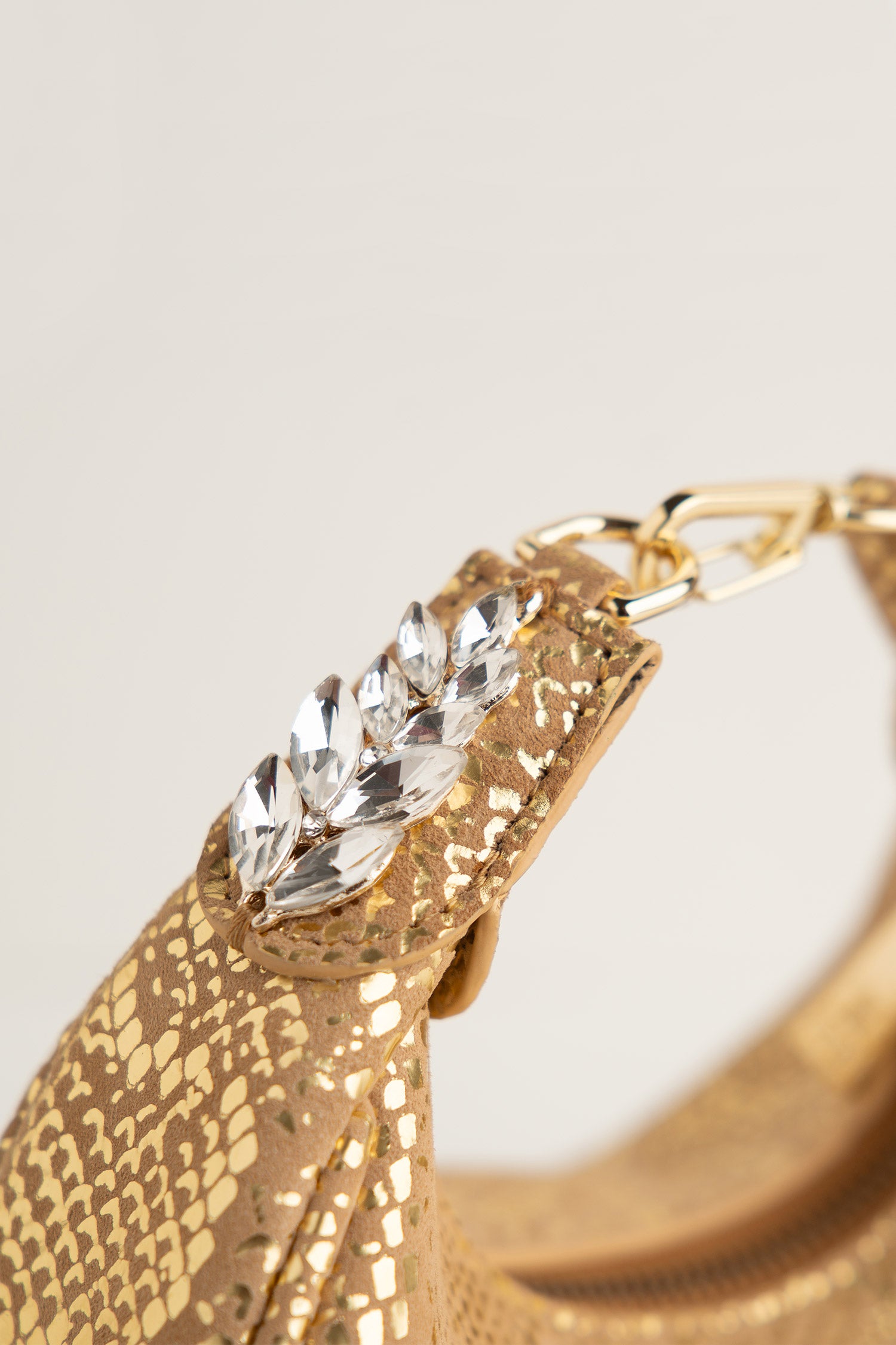 Women's leather mini halfmoon bag in gold colour with 3d reptile texture and unique clip-on handle by JULKE