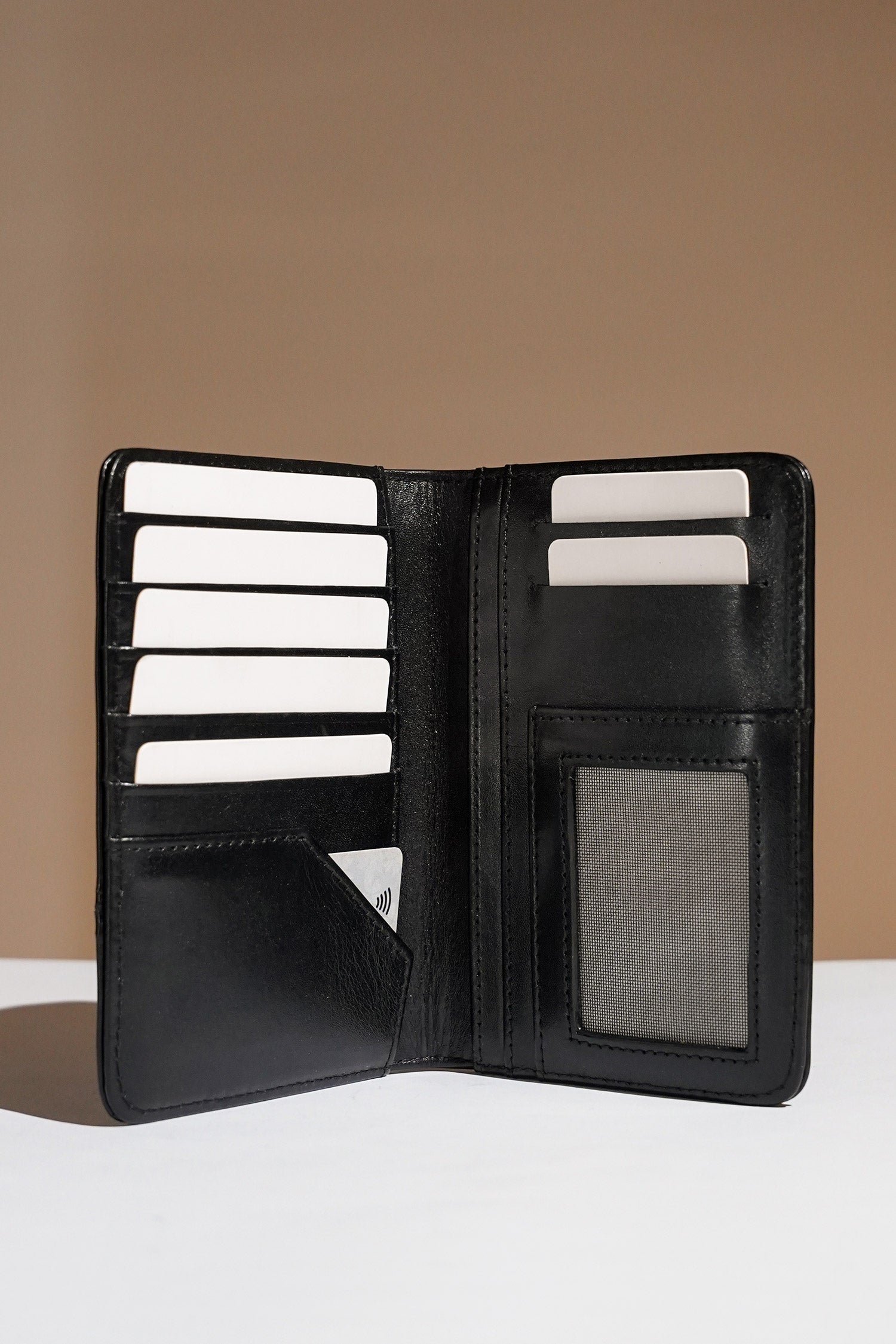 Mens leather bifold passport wallet in black colour with white contrast stitching and metal brand logo by JULKE