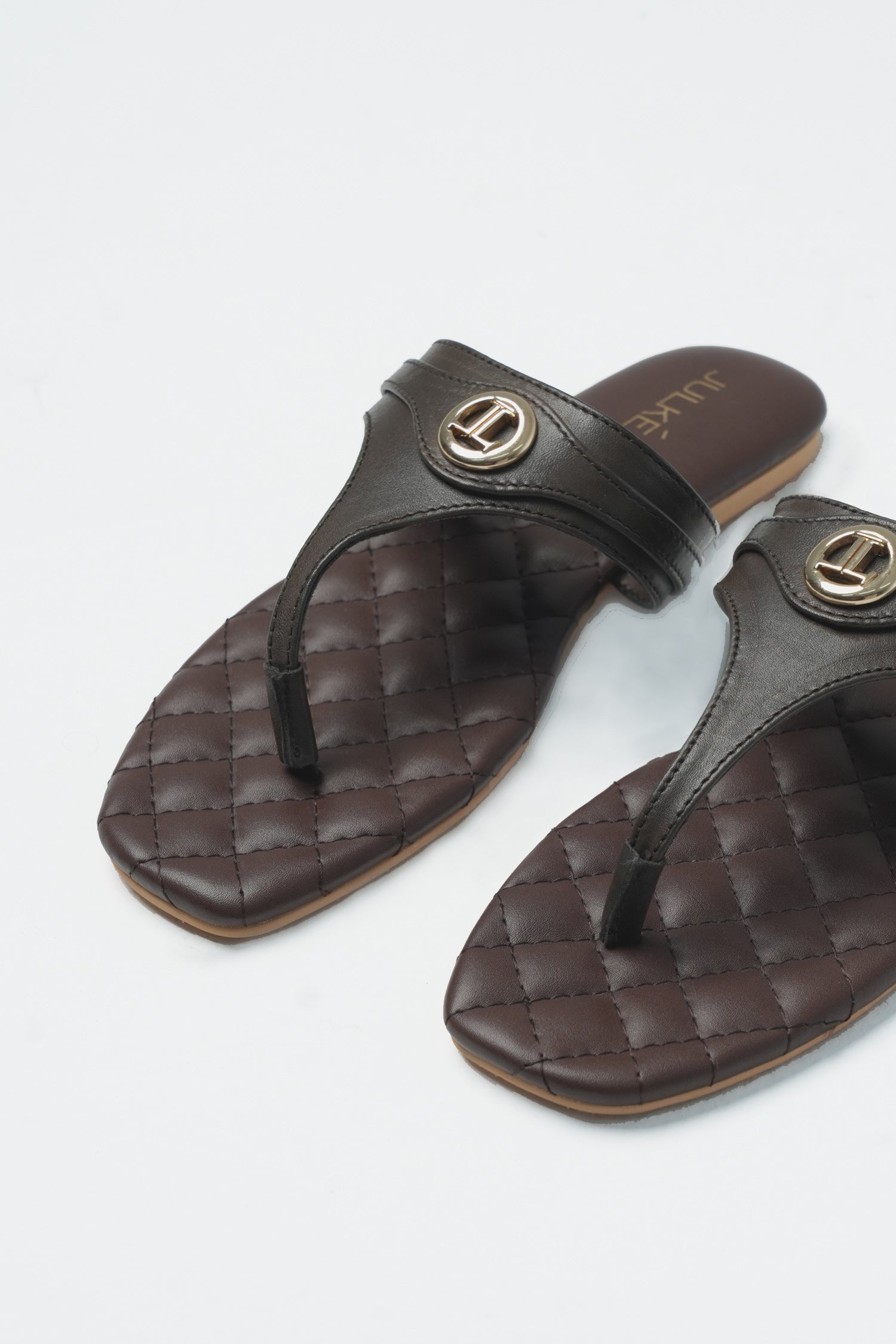 Womens leather flat thongs in dark brown colour with quilted insock and metal logo by JULKE