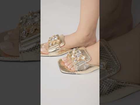 Womens flat slides in gold and white colours with glossy reptile texture and asymmetric rhinestone brooch by JULKE.