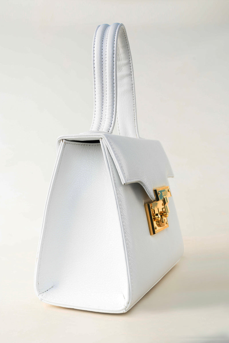 Womens statement leather hand bag in white colour with gold lock by JULKE