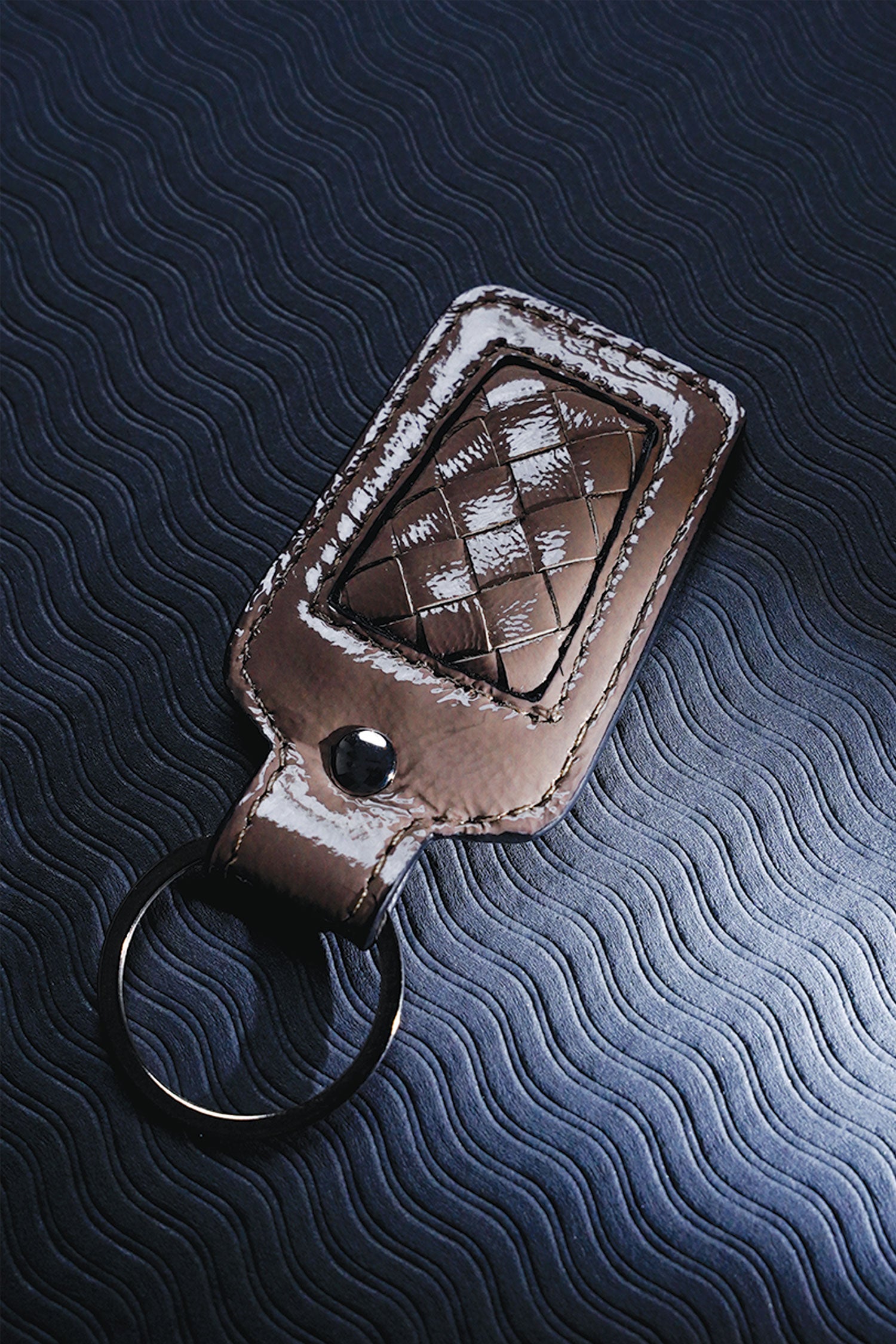 Leather key chain in grey brown colour with weaving and metal ring by JULKE