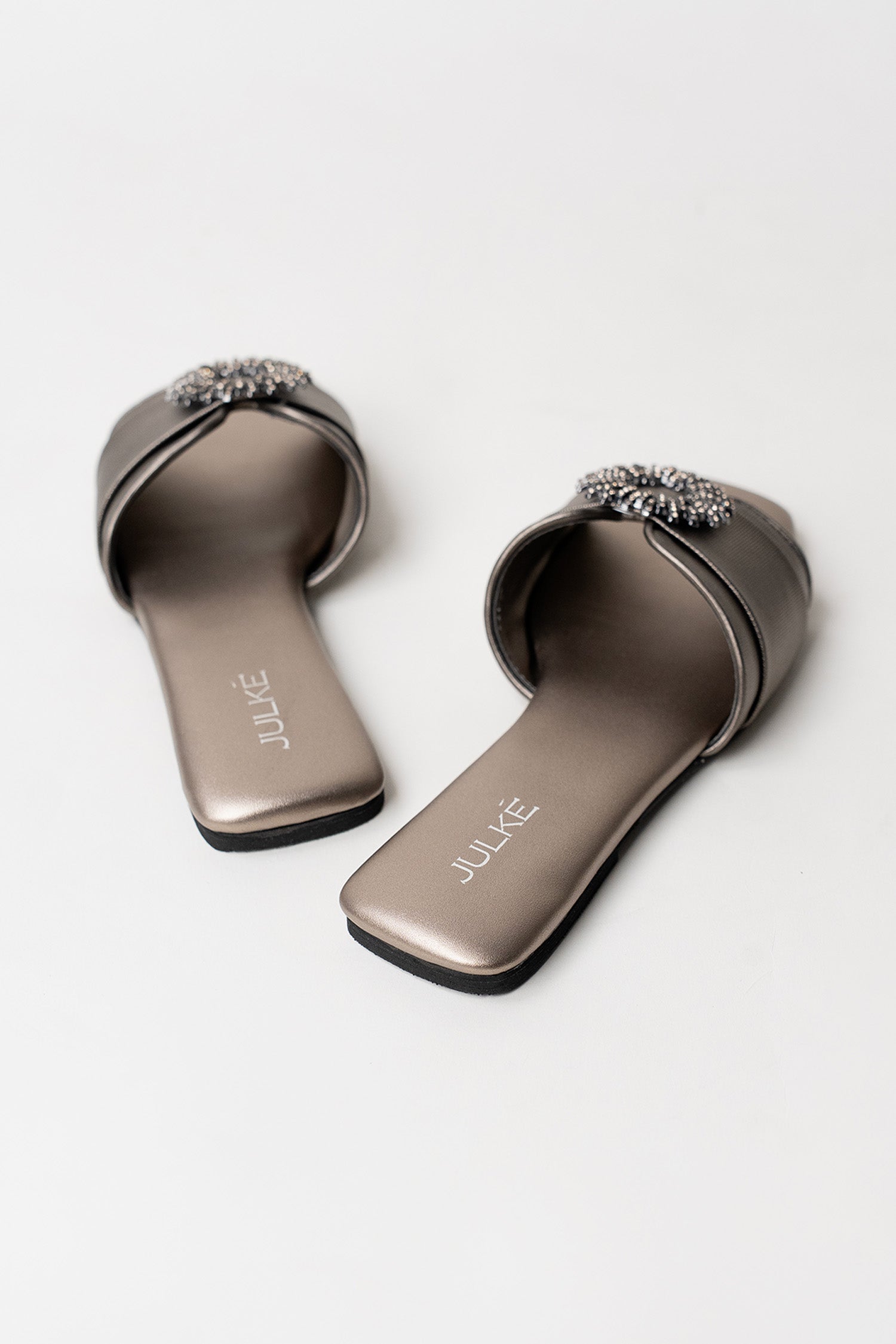 Women's festive leatherite flat shoes in gun metal colour with round silver diamante brooch and padded insock by JULKE. 