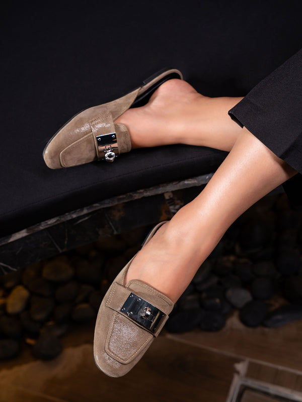Elegant women’s slip-on Loche mules by JULKÉ crafted in glossy leather with a statement metallic buckle, styled for modern sophistication and everyday ease.