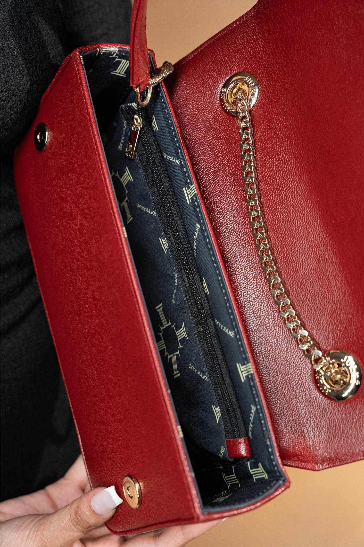 Women's leather shoulder bag in maroon colour in rectangular shape with gold horse-bit buckle of transparent circle rhinestones and short chain and leather shoulder strap by JULKE