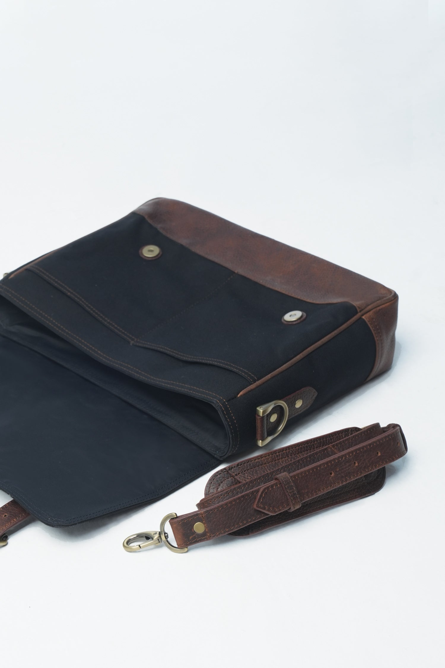 Mens leather and canvas laptop messenger bag in black and rust colour with detachable shoulder strap and pockets by JULKE