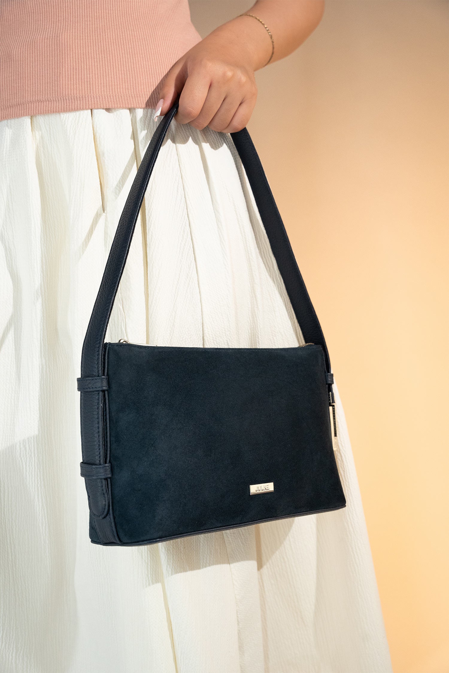 Women's suede leather mini shoulder bag in navy blue colour with contrast shoulder strap and metallic side lock by JULKE.