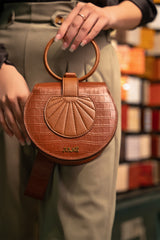 Womens leather handbag in brown colour with croc texture, round handle and wristlet by JULKE