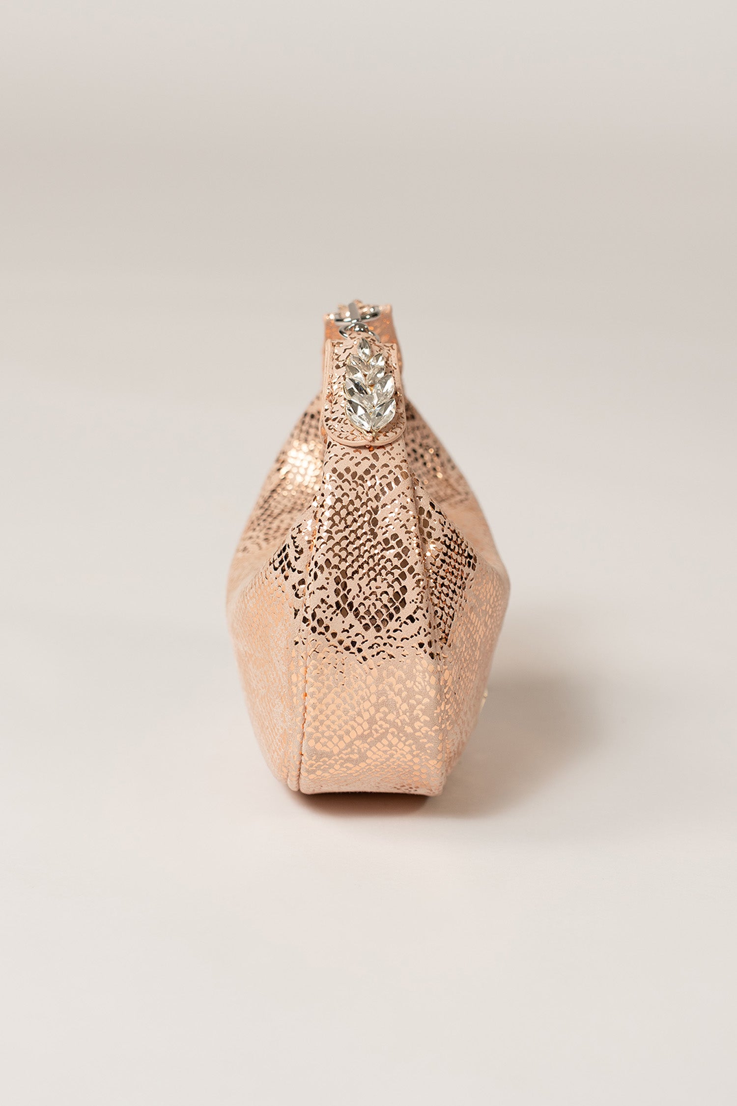 Women's leather mini halfmoon bag in light pink colour with 3d reptile texture and unique clip-on handle by JULKE.