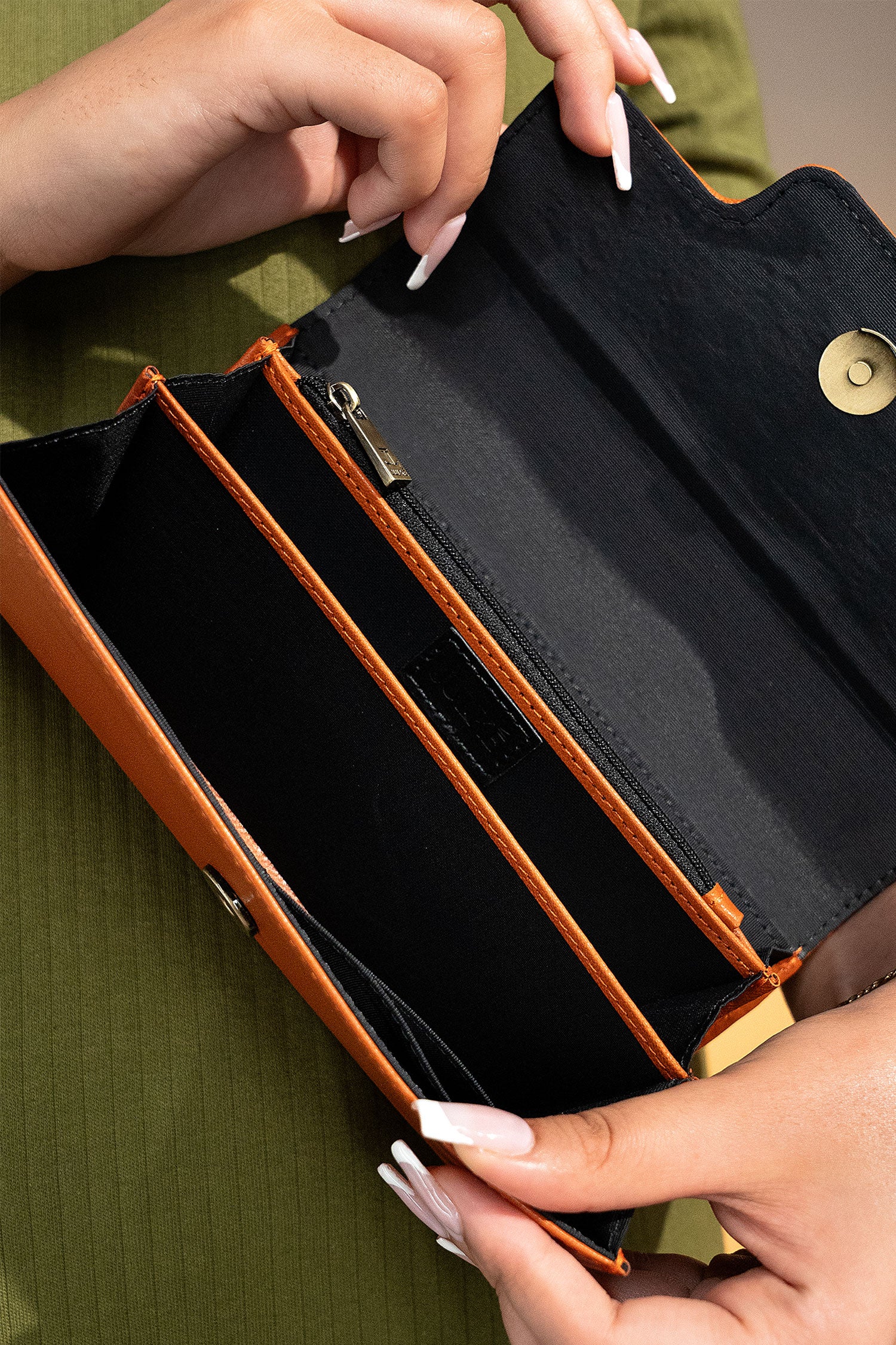 Women's leather long wallet in dark orange colour in envelope shape with long pockets and metallic horse-bit buckle and brand logo by JULKE. 