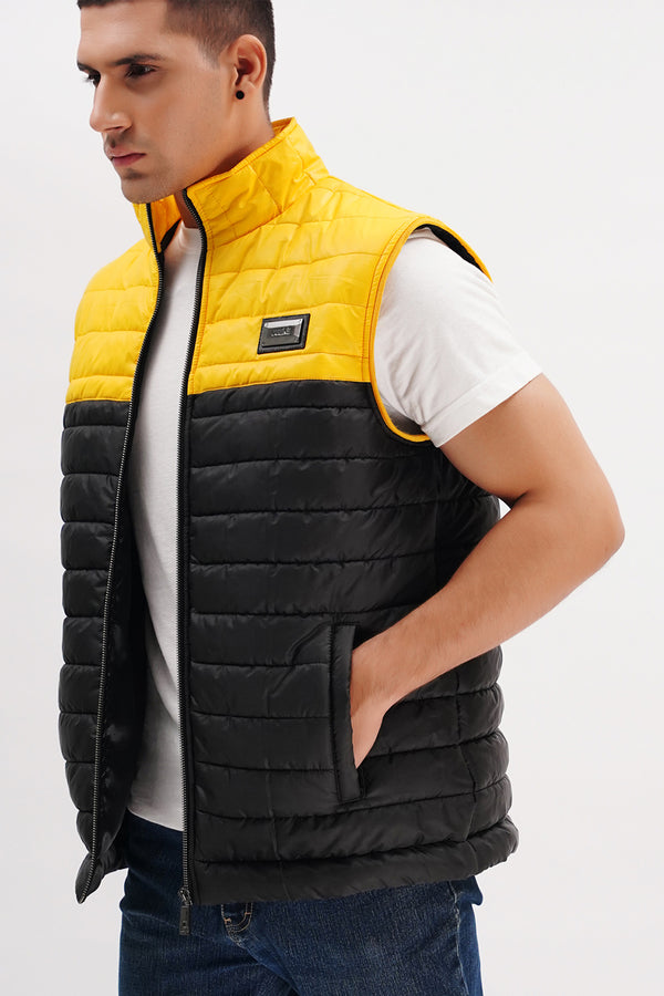 Mens sleeveless puffer vest in yellow and black wih horizontal quilting and metallic brand plate by JULKE. 